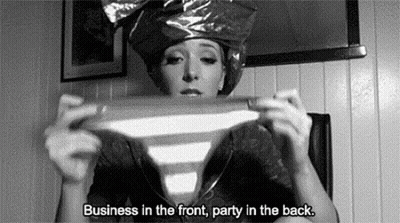 A Black And White Photo Of A Woman Wearing A Plastic Bag On Her Head Holding A Striped Shirt . GIF