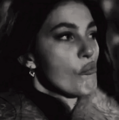 A Black And White Photo Of A Woman Wearing Earrings And Making A Funny Face . GIF