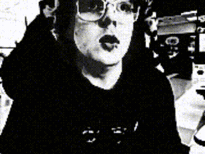 A Black And White Photo Of A Woman Wearing Glasses And A Hat GIF
