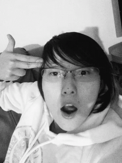 A Black And White Photo Of A Woman Wearing Glasses And A Hoodie GIF