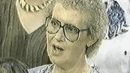 A Black And White Photo Of A Woman Wearing Glasses GIF