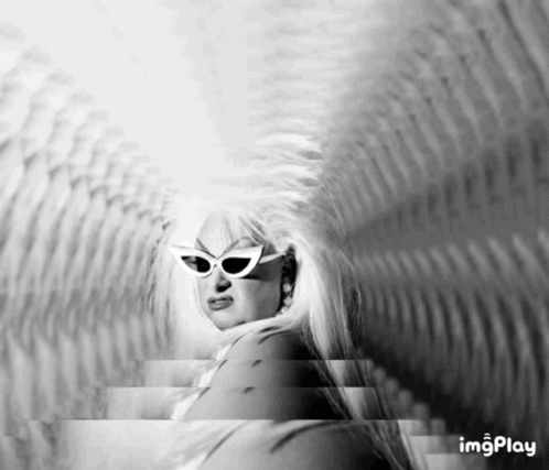 A Black And White Photo Of A Woman Wearing Sunglasses And A Wig GIF