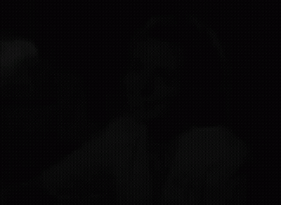 A Black And White Photo Of A Woman With A Brooch On Her Shirt GIF