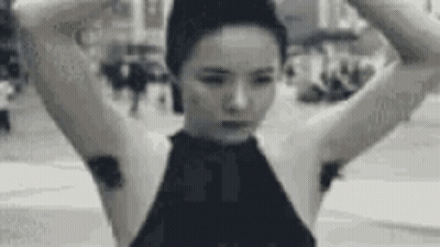 A Black And White Photo Of A Woman With A Bun On Her Head And A Bunch Of Hair On Her Armpits . GIF