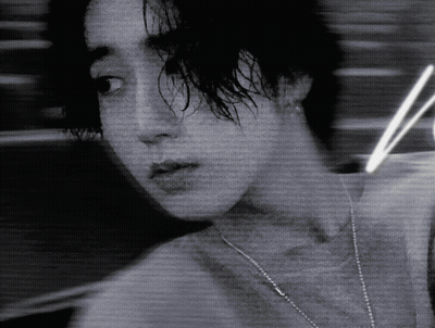 A Black And White Photo Of A Woman With A Necklace Around Her Neck GIF