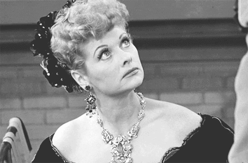 A Black And White Photo Of A Woman With A Necklace GIF