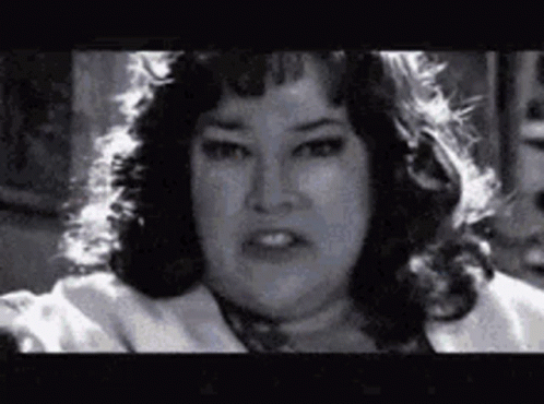 A Black And White Photo Of A Woman With A Very Serious Look On Her Face . GIF