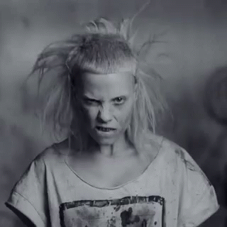 A Black And White Photo Of A Woman With A Very Strange Haircut . GIF