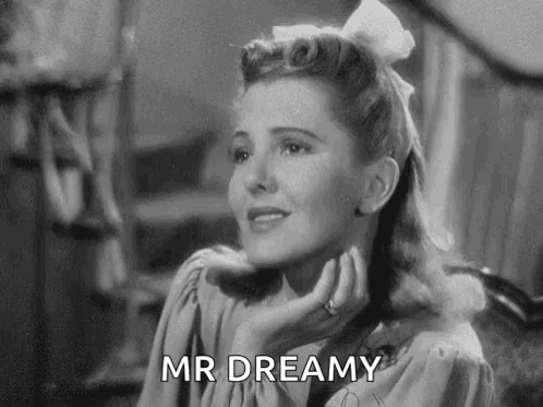 A Black And White Photo Of A Woman With A White Bow In Her Hair . GIF