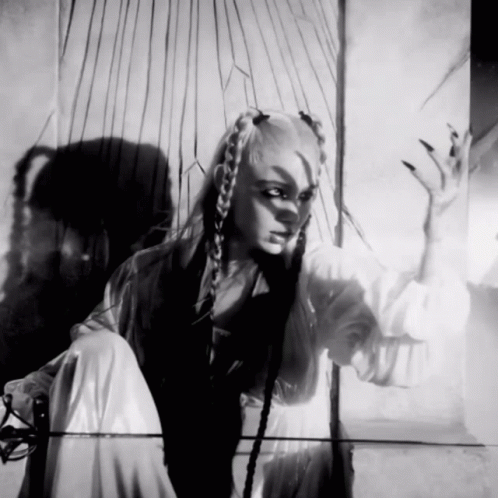 A Black And White Photo Of A Woman With Braids And Long Nails GIF