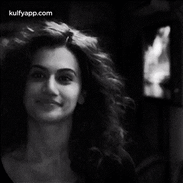 A Black And White Photo Of A Woman With Curly Hair . GIF