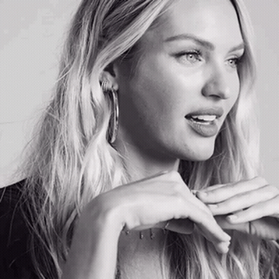 A Black And White Photo Of A Woman With Long Blonde Hair Wearing Hoop Earrings GIF