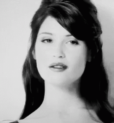 A Black And White Photo Of A Woman With Long Hair And A Fringe . GIF