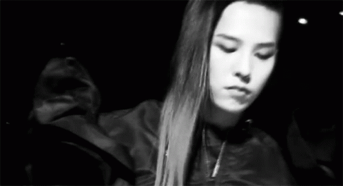 A Black And White Photo Of A Woman With Long Hair In A Jacket . GIF