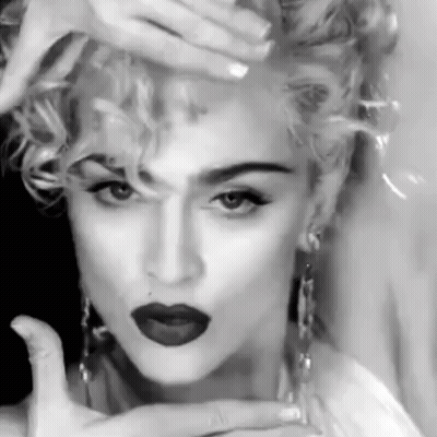 A Black And White Photo Of A Woman With Red Lipstick And Curly Hair . GIF