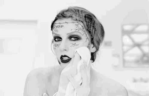 A Black And White Photo Of A Woman With Tattoos On Her Face GIF