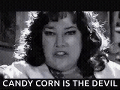 A Black And White Photo Of A Woman With The Words `` Candy Corn Is The Devil '' Written On It . GIF