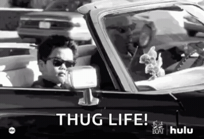 A Black And White Photo Of A Young Boy Driving A Car With The Words `` Thug Life '' Written On It . GIF