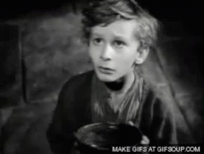 A Black And White Photo Of A Young Boy Holding A Bowl GIF