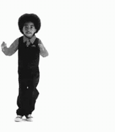 A Black And White Photo Of A Young Boy In Overalls Dancing . GIF