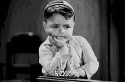 A Black And White Photo Of A Young Boy Sitting At A Desk With His Hand On His Face . GIF