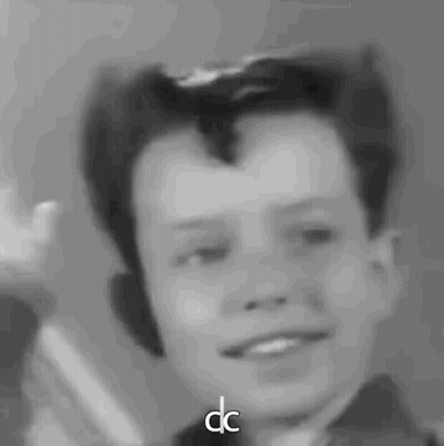 A Black And White Photo Of A Young Boy With The Letters Dc Next To Him GIF