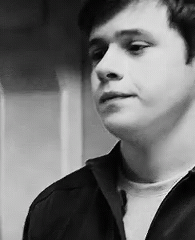 A Black And White Photo Of A Young Man In A Black Jacket . GIF