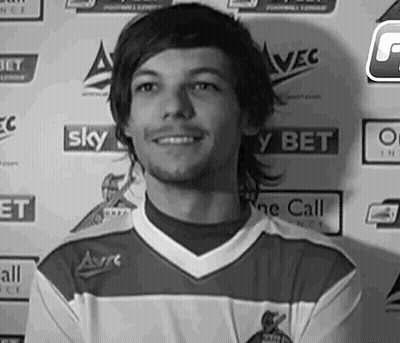 A Black And White Photo Of A Young Man In A Soccer Jersey Smiling . GIF