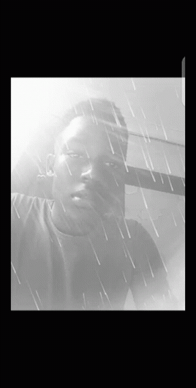 A Black And White Photo Of A Young Man In The Rain GIF