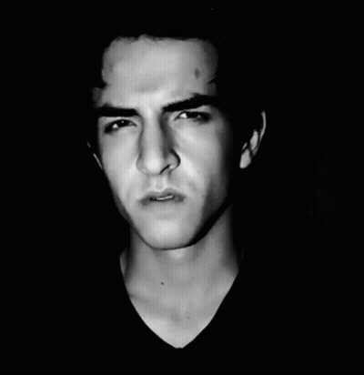 A Black And White Photo Of A Young Man Making A Face GIF