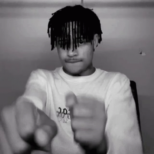 A Black And White Photo Of A Young Man Pointing At The Camera GIF