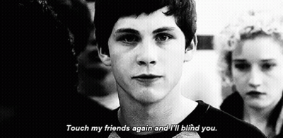 A Black And White Photo Of A Young Man Standing In Front Of A Crowd . GIF