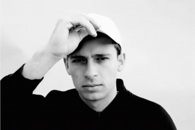 A Black And White Photo Of A Young Man Wearing A Hat GIF
