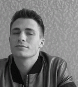 A Black And White Photo Of A Young Man Wearing A Leather Jacket And Looking At The Camera . GIF