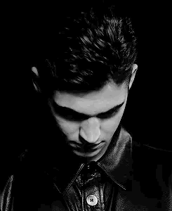 A Black And White Photo Of A Young Man Wearing A Leather Jacket And Looking At The Camera . GIF