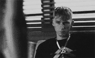 A Black And White Photo Of A Young Man Wearing A Medal GIF