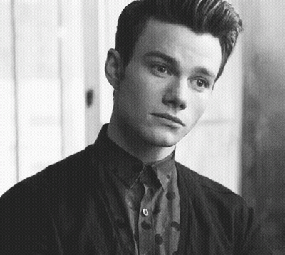 A Black And White Photo Of A Young Man Wearing A Polka Dot Shirt And Jacket . GIF