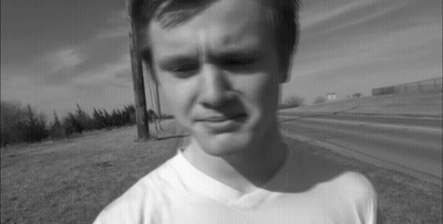 A Black And White Photo Of A Young Man Wearing A White T-Shirt GIF