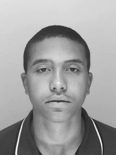 A Black And White Photo Of A Young Man With A Shaved Head GIF