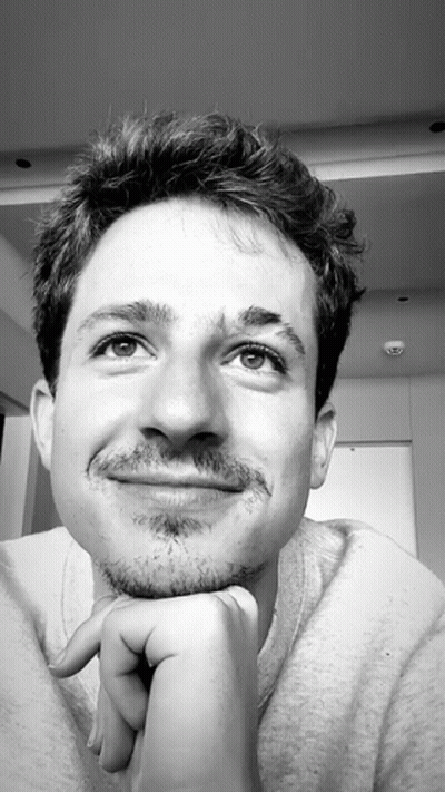 A Black And White Photo Of A Young Man With His Hand On His Chin GIF