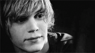 A Black And White Photo Of A Young Man With Long Blonde Hair . GIF