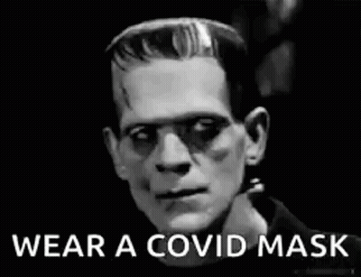 A Black And White Photo Of Frankenstein Wearing A Mask . GIF