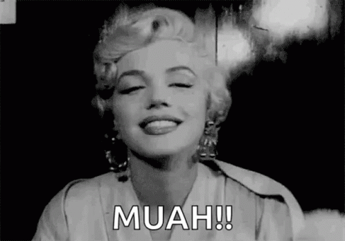 A Black And White Photo Of Marilyn Monroe Smiling With The Words Muah Written Next To Her . GIF