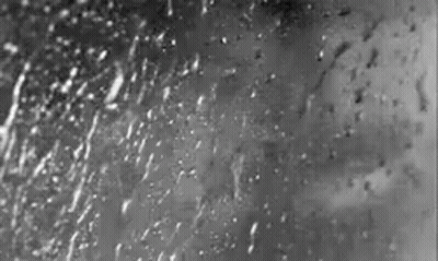 A Black And White Photo Of Rain Drops On A Window GIF