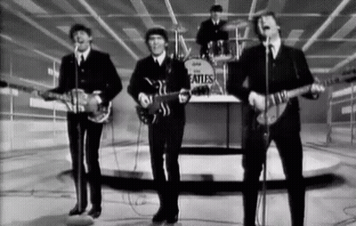 A Black And White Photo Of The Beatles Playing Guitars And Singing Into Microphones . GIF