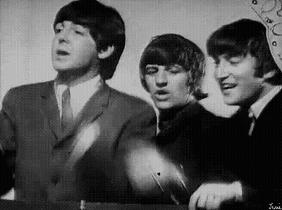 A Black And White Photo Of The Beatles Singing . GIF
