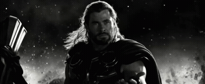 A Black And White Photo Of Thor Holding A Hammer And Cape GIF