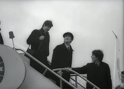 A Black And White Photo Of Three Men Walking Up Stairs . GIF