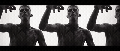 A Black And White Photo Of Three Men With Tattoos On Their Bodies . GIF