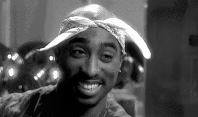 A Black And White Photo Of Tupac Shakur Smiling GIF